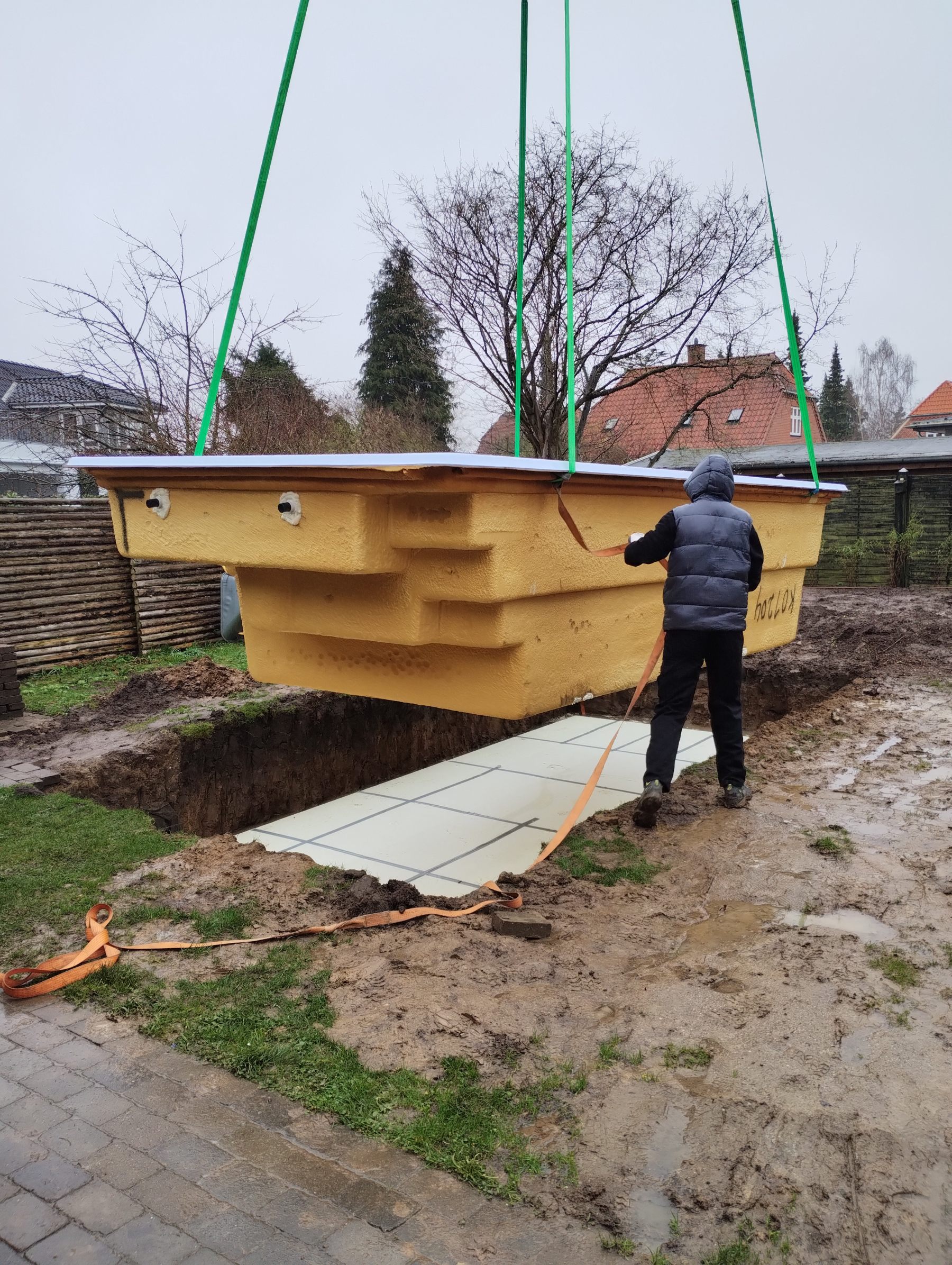 Poolen løftes på plads med kran over det udgravede hul