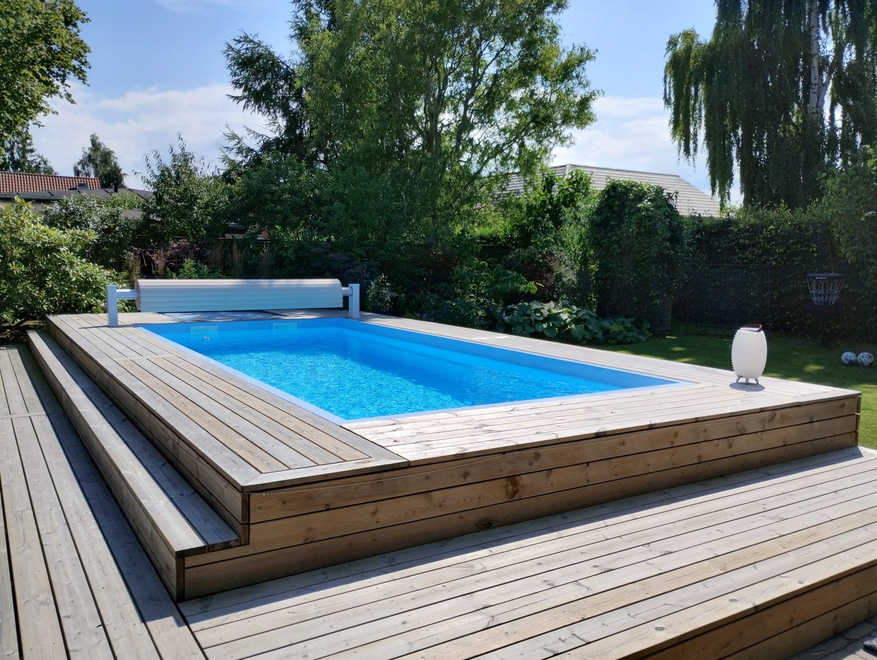 Færdig pool med træterrasse i baghaven